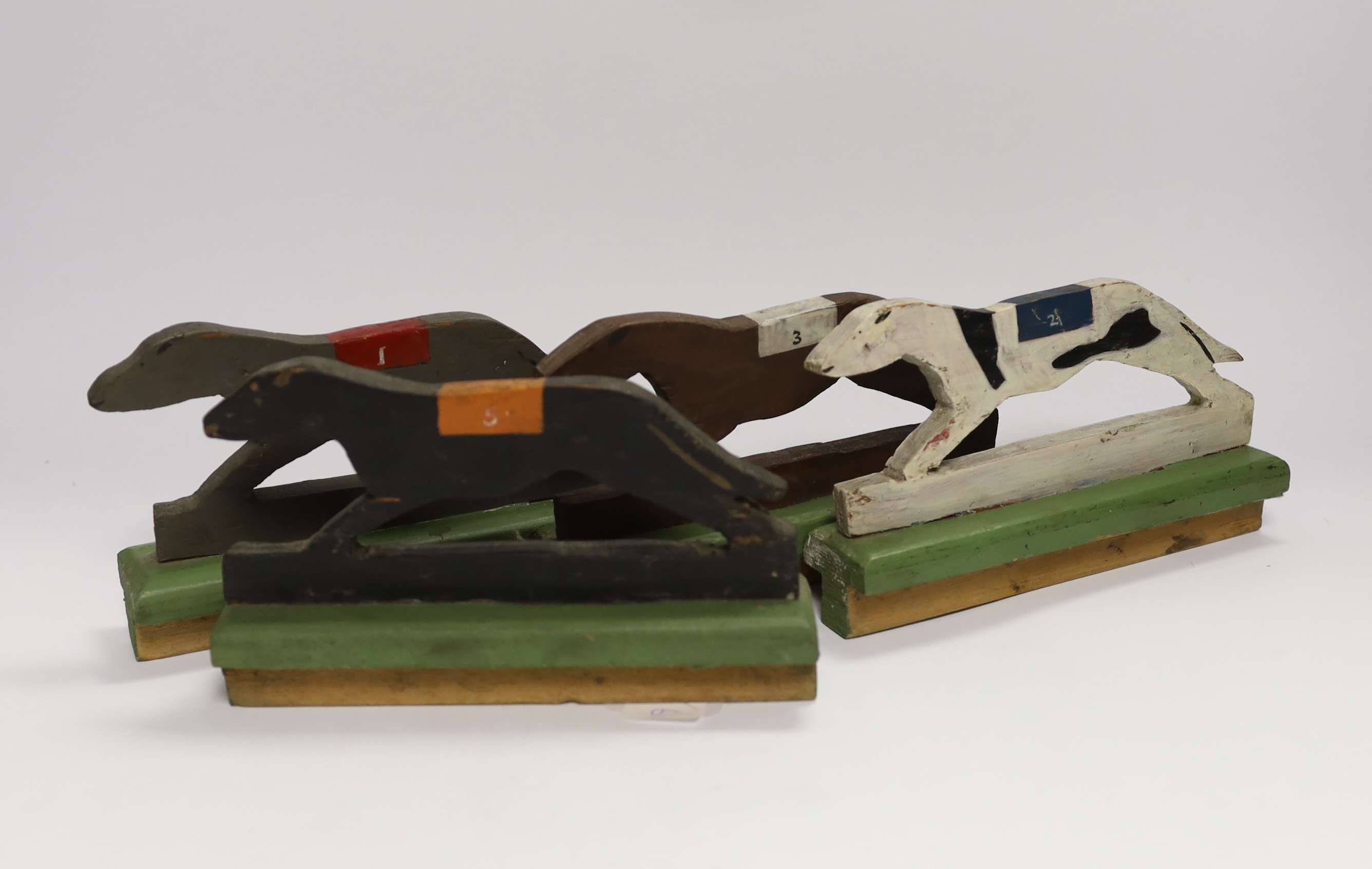 A painted wood greyhound racing game and three wooden dice, 19cm wide